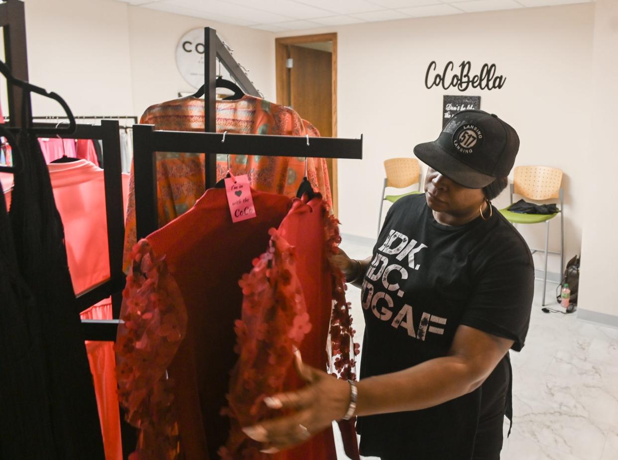 Beeka Monique of CoCoBella organizes clothing racks at the Middle Village Micro Market, on Wednesday, May 8, 2024, in downtown Lansing.