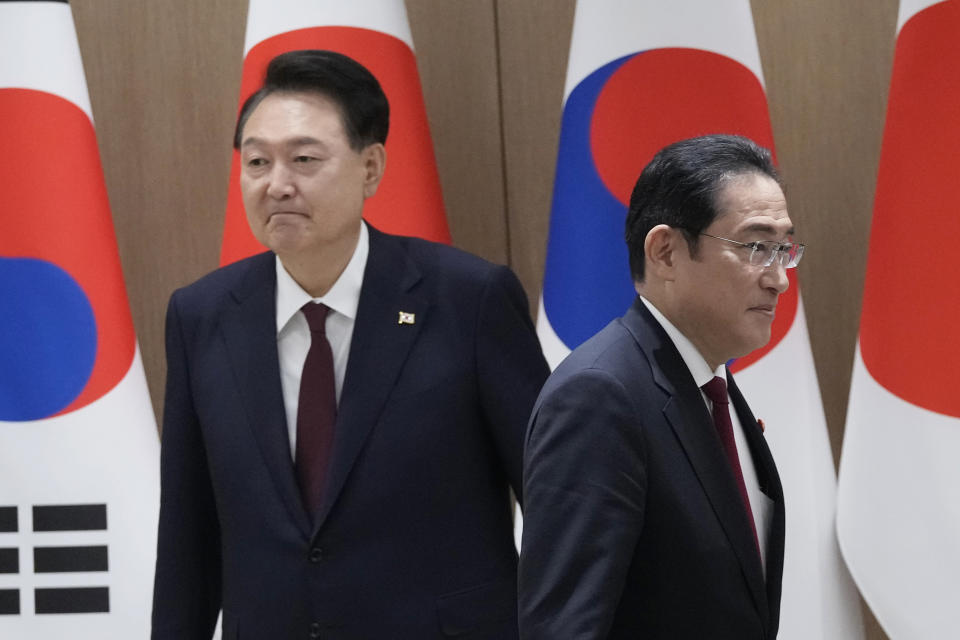 South Korean President Yoon Suk Yeol, left, and Japanese Prime Minister Fumio Kishida move their positions during a meeting at the Presidential Office in Seoul, South Korea, Sunday, May 26, 2024. (AP Photo/Ahn Young-joon, Pool)