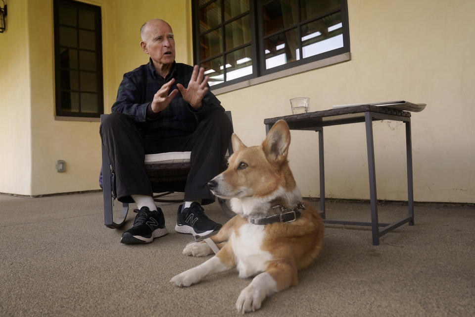 With his dog, Colusa at his feet, former California Gov. Jerry Brown discusses his life out of office, at his ranch near Williams, Calif., Wednesday, March 2, 2022. The 83-year-old, who left office in 2019, serves as executive chairman of the Bulletin of the Atomic Scientists, which sets the Doomsday Clock measuring how close humanity is to self-destruction. He's also on the board of the Nuclear Threat Initiative. (AP Photo/Rich Pedroncelli)