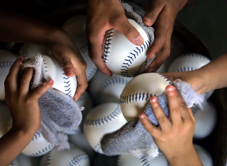 MACUELIZO, HONDURAS: Honduran children clean softballs 05 march 2002, made at a factory in Macuelizo, Santa Barbara, Honduras, 320 kms northwest of Tegucigalpa. Workers receive 11 cents USD for each ball they make. Ninos limpian el 05 de marzo del 2002 las pelotas de softbol fabricadas en el municipio de Macuelizo, Santa Barbara, 320 km al noroeste de Tegucigalpa, que seran exportadas a Estados Unidos a un costo de 11 centavos la unidad. (Photo credit should read ORLANDO SIERRA/AFP via Getty Images)