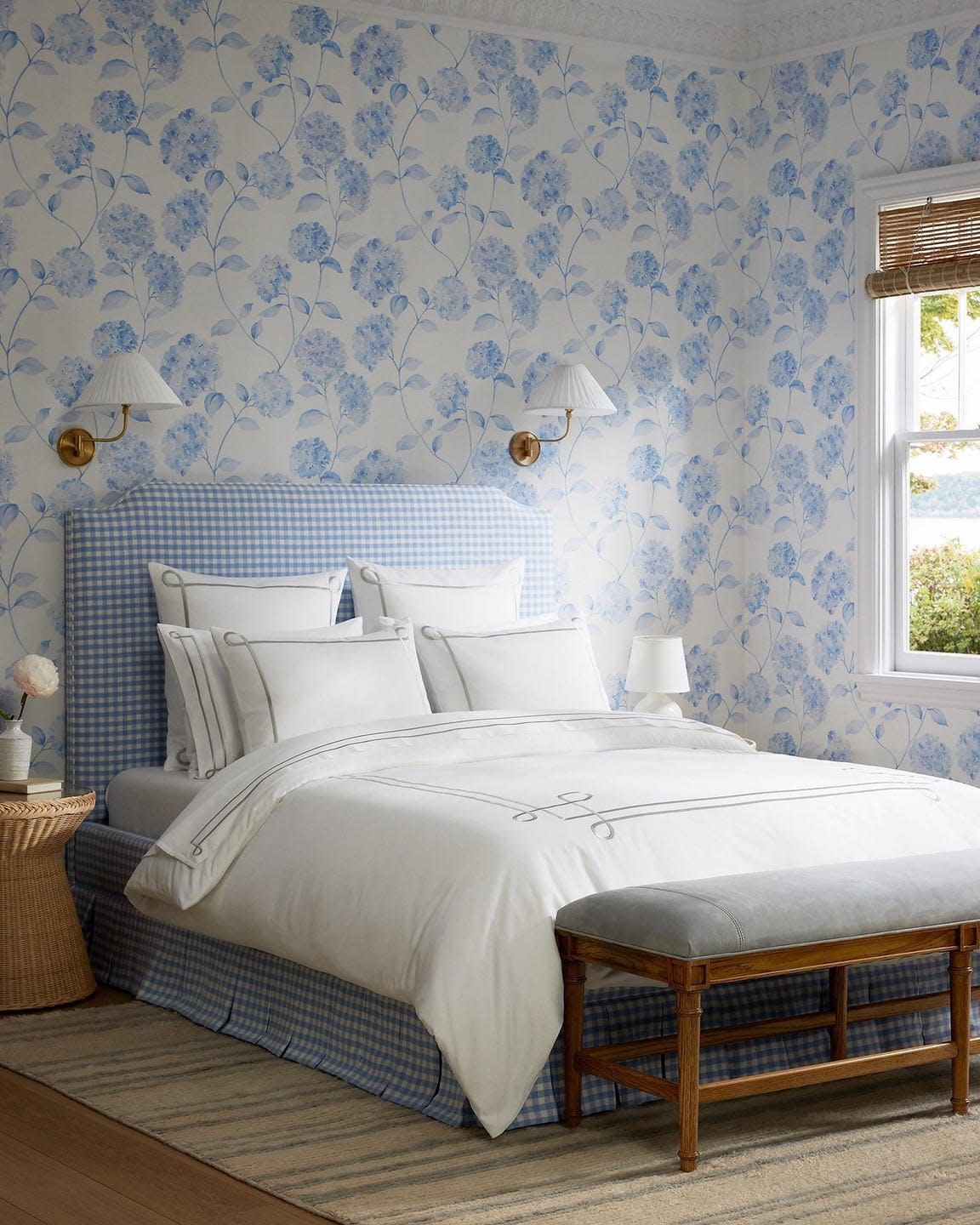 a bed with a blue and white wallpaper