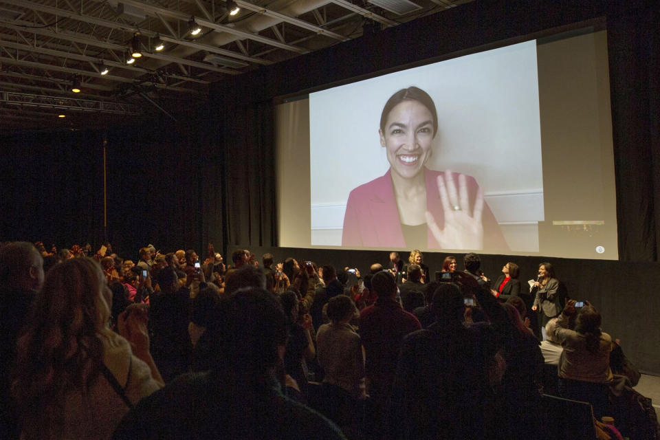 FILE - In this Sunday, Jan. 27, 2019 file photo, Rep. Alexandria Ocasio-Cortez, D-N.Y. waves as she appears on screen via video conference for a question and answer session after the premiere screening of the documentary "Knock Down the House" during the 2019 Sundance Film Festival in Park City, Utah. On Friday, Feb. 15, 2018, The Associated Press has found that stories circulating on the internet that the congresswoman received $10 million for the documentary, are untrue. (Photo by Danny Moloshok/Invision/AP)