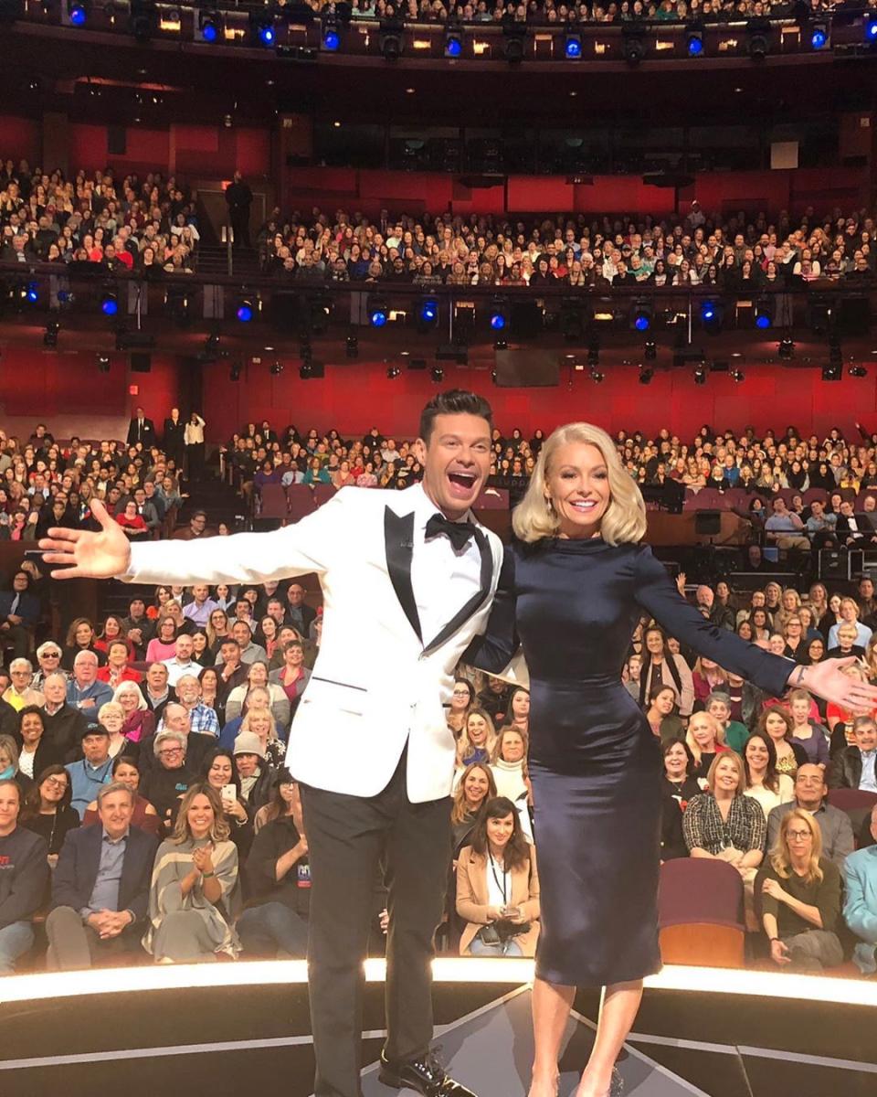 Kelly Ripa and Ryan Seacrest pose on stage