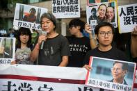 A small group of protesters led by rebel lawmaker Leung Kwok-hung (C) gathered outside the convention centre calling for the release of political prisoners in China