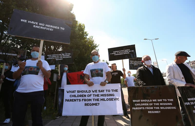 People hold signs as show support for Kosovo's President Hashim Thaci in front of the special tribunal, in The Hague