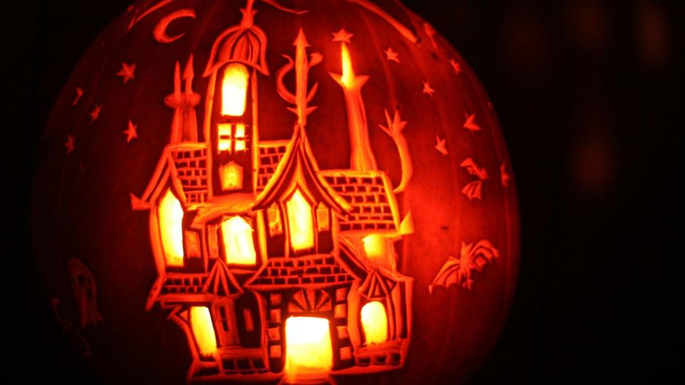 carved pumpkin with haunted house