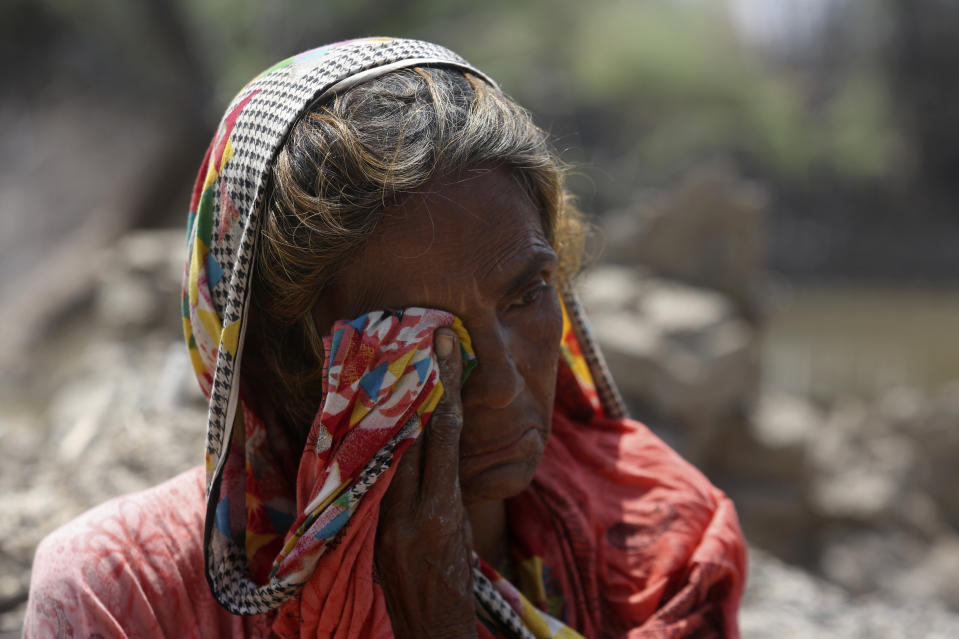 Muktiyara Bibi, 51, cries next to her rain-damaged home, in Shikarpur district of Sindh province, of Pakistan, Tuesday, Aug. 30, 2022. Disaster officials say nearly a half million people in Pakistan are crowded into camps after losing their homes in widespread flooding caused by unprecedented monsoon rains in recent weeks. (AP Photo/Fareed Khan)