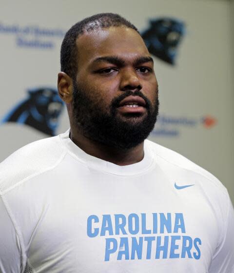 Football player Michael Oher poses in a white Carolina Panthers t-shirt