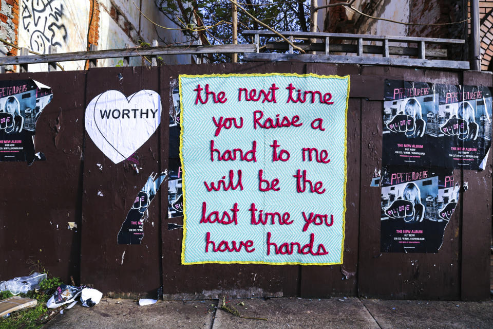 This December 2016 photo provided by ishknits shows a knitted yarn bomb installed on an abandoned wall in Philadelphia, Pa., embroidered with a quote from the character Daenerys Targaryen in the show "Game of Thrones." Knitters and crocheters call it yarn bombing. They're using fiber arts to make political statements, or maybe just to lift people's spirits. Experts say yarn bombing is part of a long tradition in which women use textile arts to agitate, excite or inspire. (Conrad Benner/StreetsDept.com/ishknits via AP)