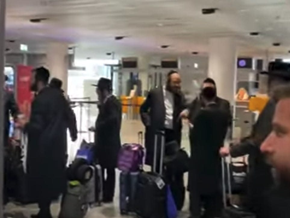 Orthodox Jewish passengers wait in line after being barred from boarding a connecting Lufthansa flight to Budapest.