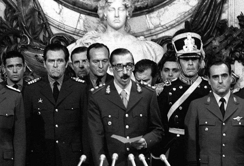 FILE - In this March 24, 1976 file photo, Argentina's dictator Gen. Jorge Rafael Videla, center, is sworn-in as president at the Government House in Buenos Aires, Argentina. With a world divided by the Cold War, South America's dictatorships in 1975 agreed to start exchanging information on political dissidents, trade unionists, students and any individual suspected of being leftist, in a campaign known as Operation Condor, often with U.S. support. (AP Photo/Eduardo Di Baia, File)