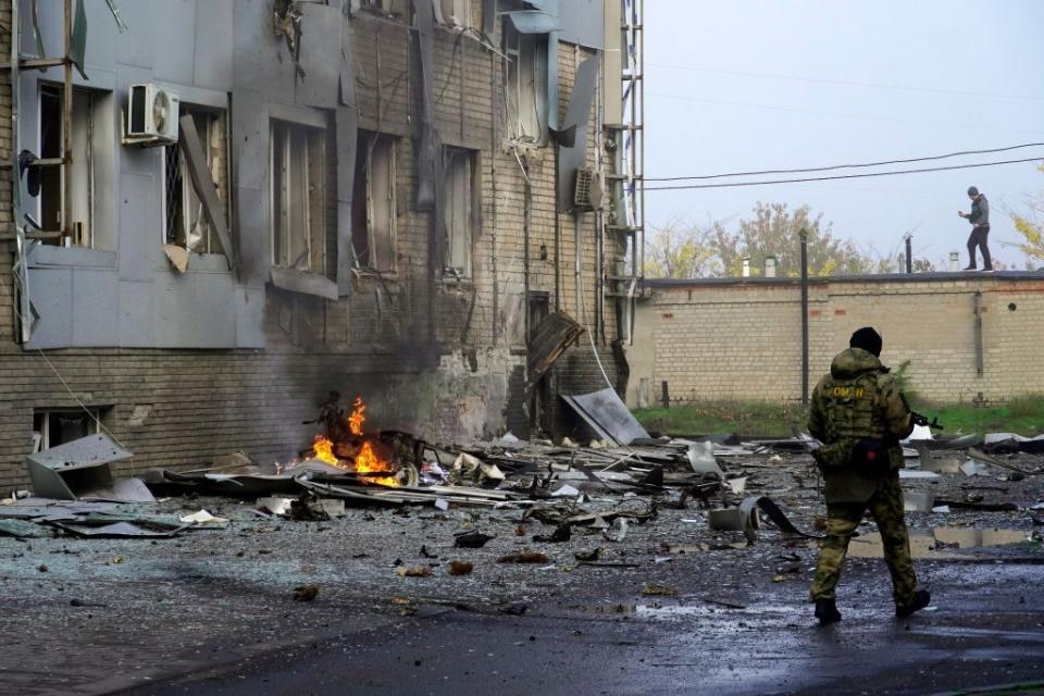 A Russian serviceman guards the site of a car bomb explosion outside a building housing a local TV station in the Russian-occupied city of Melitopol on Oct. 25, 2022. (Photo by STRINGER/AFP via Getty Images)