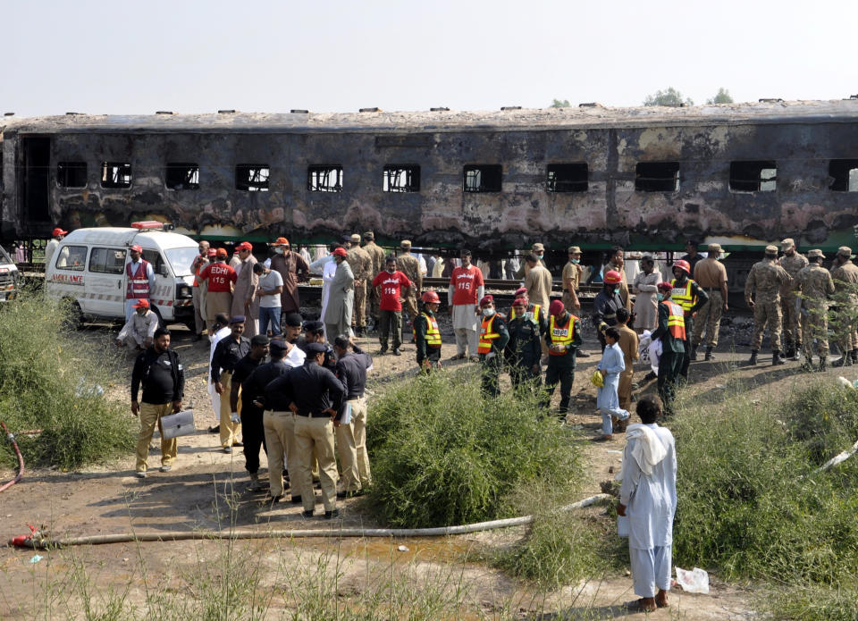 Pakistani soldiers and officials examine a train damaged by a fire in Liaquatpur, Pakistan, Thursday, Oct. 31, 2019. A massive fire engulfed three carriages of the train traveling in the country's eastern Punjab province (AP Photo/Siddique Baluch)