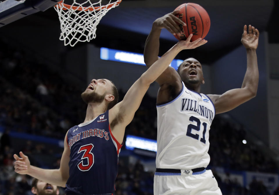 Villanova's Dhamir Cosby-Roundtree (21) blocks a shot by St. Mary's Jordan Ford (3) during the first half of a first round men's college basketball game in the NCAA Tournament, Thursday, March 21, 2019, in Hartford, Conn. (AP Photo/Elise Amendola)