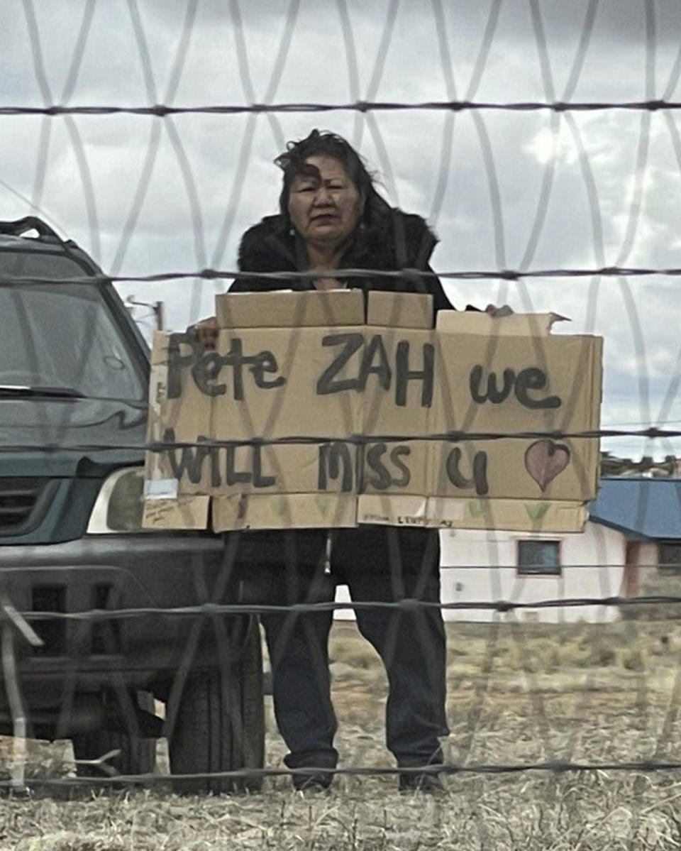 In this photo provided by the Navajo Nation Office of the President and Vice President a mourner holds a sign along the funeral procession route for former Navajo President Peterson Zah in Low Mountain, Ariz., Saturday, March 11, 2023. Zah was the first president elected on the Navajo Nation in the 1990 after the tribe restructured its government into three branches to prevent power from being concentrated in the chairmanship. (Navajo Nation Office of the President and Vice President via AP)