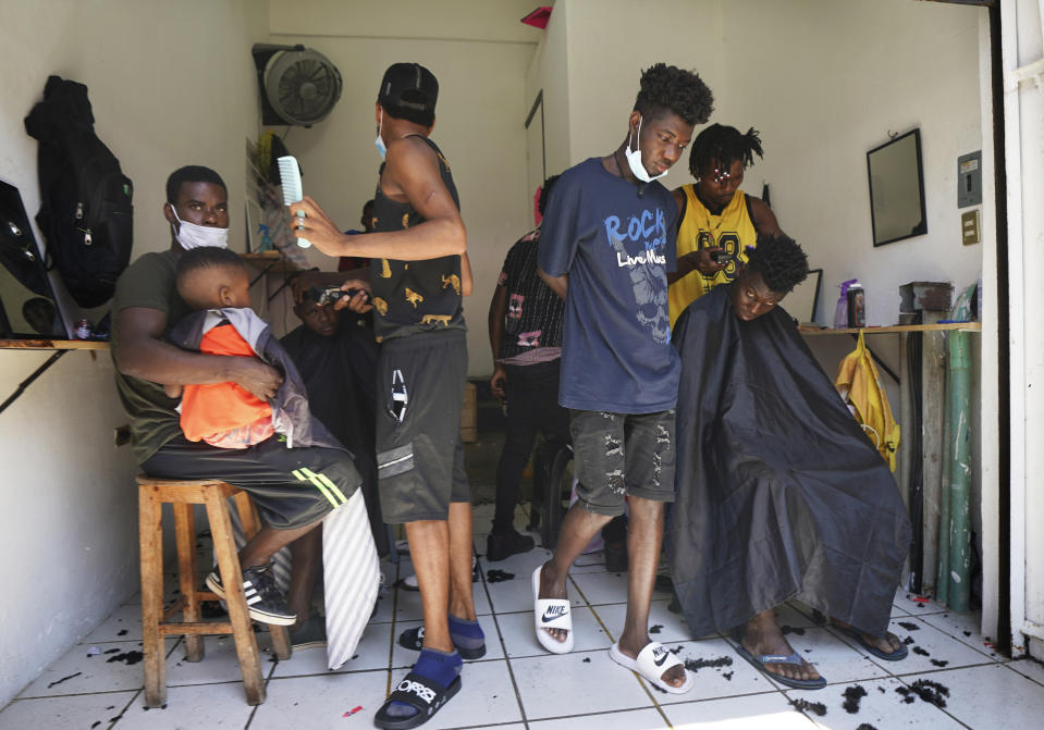 FILE - In this Sept. 3, 2021 file photo, Haitian migrants gather in a makeshift barbershop in Tapachula, Mexico. Thousands of mostly Haitian migrants have been stuck in the southern city of Tapachula, many waiting here for months and some up to a year for asylum requests to be processed. (AP Photo/Marco Ugarte, File)