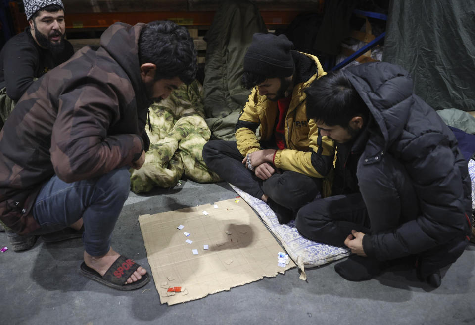 Migrants plays in the logistics center of the checkpoint "Bruzgi" at the Belarus-Poland border near Grodno, Belarus, Wednesday, Dec. 1, 2021. The West has accused Belarusian President Alexander Lukashenko of luring thousands of migrants to Belarus with the promise of help to get to Western Europe to use them as pawns to destabilize the 27-nation European Union in retaliation for its sanctions on his authoritarian government. Belarus denies engineering the crisis. (Oksana Manchuk/BelTA via AP)