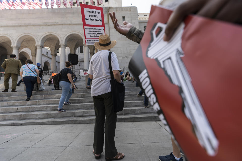 Pro housing activists rally outside Los Angeles City Hall Thursday morning July 1, 2021. Los Angeles City Council is poised to clamp down on homeless encampments, making it illegal to pitch tents on some sidewalks, beneath overpasses and near parks. The measure being considered Thursday, July 1, 2021, is billed as a humane way to get people off streets and restore access to public spaces. (AP Photo/Damian Dovarganes)