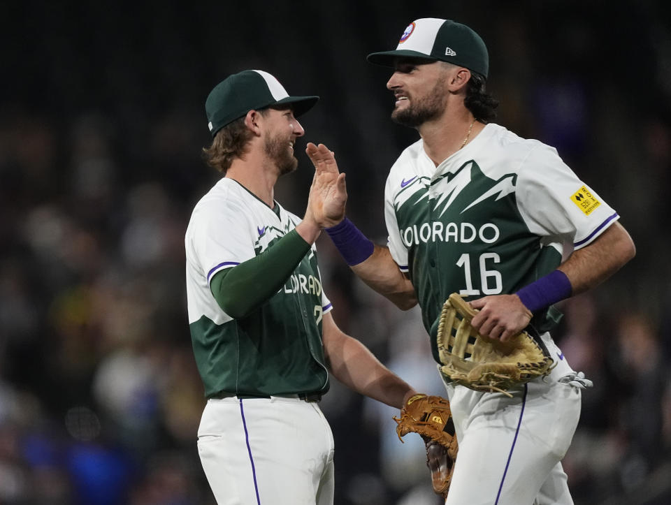 Colorado Rockies third baseman Ryan McMahon, left, is congratulated by center fielder Sam Hilliard after defeating the Kansas City Royals in a baseball game Saturday, July 6, 2024, in Denver. (AP Photo/David Zalubowski)