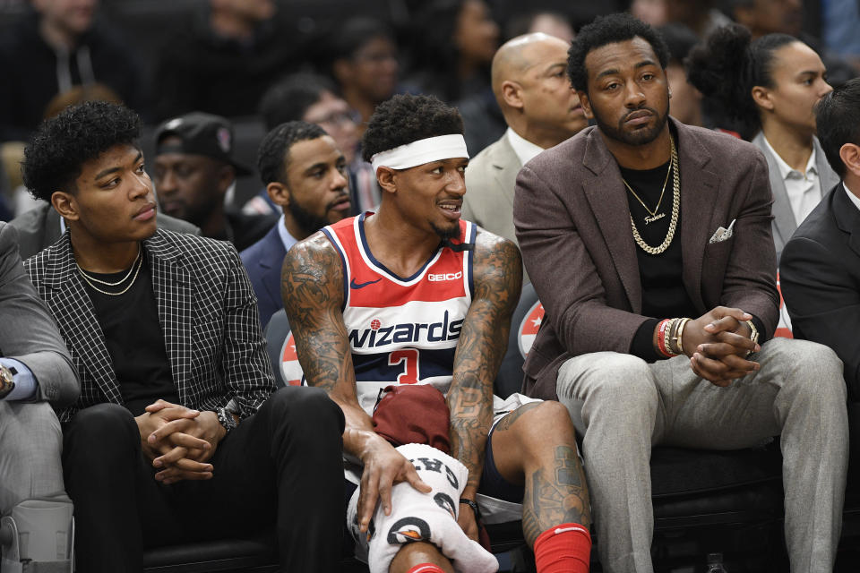 Washington Wizards forward Rui Hachimura, left, of Japan, guard Bradley Beal, center, and guard John Wall, right, watch from the bench during the first half of an NBA basketball game against the Utah Jazz, Sunday, Jan. 12, 2020, in Washington. (AP Photo/Nick Wass)