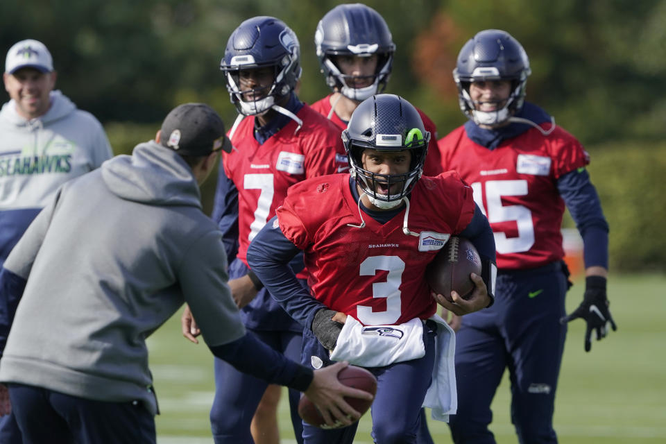 Seattle Seahawks quarterback Russell Wilson (3) keeps his injured hand in a pad as he runs through a warmup drill with backup quarterback Geno Smith (7) behind him during NFL football practice, Wednesday, Oct. 13, 2021, in Renton, Wash. Wilson had surgery on his hand last Friday, and Smith is expected to be the starting quarterback Sunday when the Seahawks play the Pittsburgh Steelers on the road. (AP Photo/Ted S. Warren)