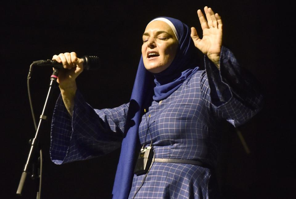 sinead o connor performing on stage singing into a microphone