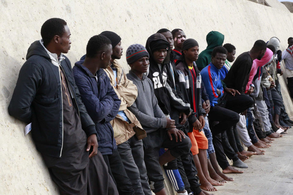 FILE - Migrants stand after being brought to shore by a Libyan coast guard at the Mediterranean Sea, in Garaboli Libya, Oct. 18, 2021. Though migrants have long faced torture and extortion in the Libya, a crossroads for Africans and Middle Easterners trying to reach Europe, rights groups and half a dozen former detainees say the abuse is taking on a more organized and dangerous nature under a new government-funded body called the Stability Support Authority. (AP Photo/Yousef Murad, File)