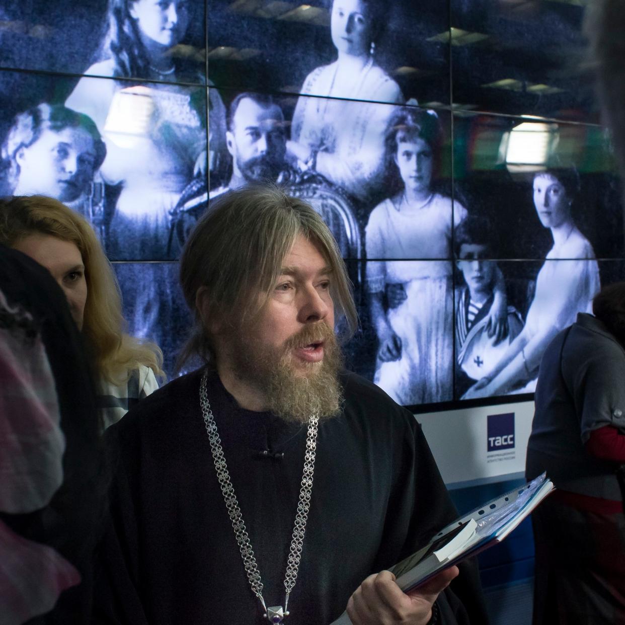 Bishop Tikhon Shevkunov, who has suggested Nicholas II's killing was a 'ritual murder,' stands in front of a photograph of the tsar and his family in 2015.   - AP