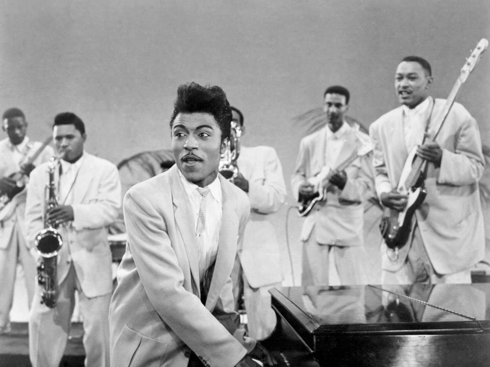 Musician Little Richard performs onstage with his band as his saxophone player Grady Gaines stands on the piano in circa 1957 in scene from the movie 'Mister Rock And Roll.'