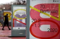 A pedestrian walks past an advertising billboard for the upcoming 70th Berlinale International Film Festival in Berlin