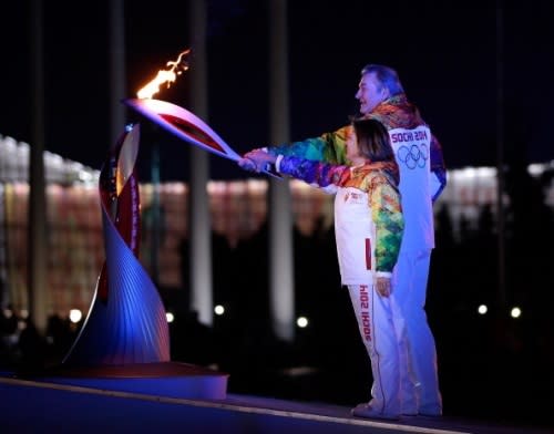 Irina Rodnina and Vladislav Tretyak light the Olympic cauldron during the opening ceremony