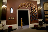 <p>A staff member poses for photographs next to works including an installation of ceramic bowls by Afghan potter Abdul Matin Malekzada, which are one of 100 art works selected by Britain’s Prince Charles to feature in a display entitled “Prince & Patron” to mark his 70th birthday year, in the Ball Supper Room at Buckingham Palace in London, Thursday, July 19, 2018. The 100 works are being displayed for the summer opening of the state rooms, open to visitors from July 21 until September 30. (AP Photo/Matt Dunham) </p>