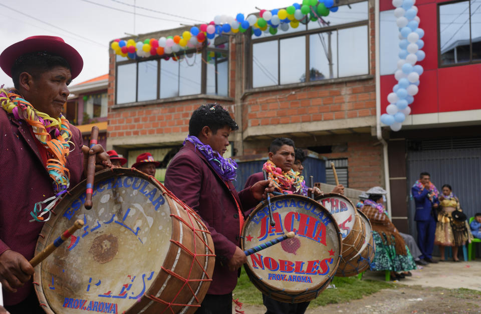 Músicos tocando mientras parejas indígenas aymara bailan en el "Martes de Challa", una celebración que forma parte del carnaval boliviano en que se hacen ofrendas a la Pachamama o Madre Tierra, en Achocalla, Bolivia, el martes 13 de febrero de 2024. (AP Foto/Juan Karita)