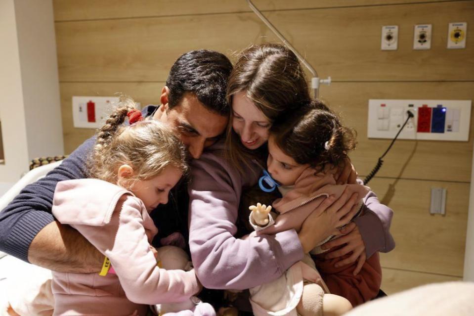 FILE - In this photo provided by the Schneider Children's Medical Center, siblings Aviv Asher, Raz Asher, and mother, Doron, react as they meet with Yoni, Doron's husband and their father, after they returned to Israel at the Schneider Children's Medical Center, on Nov. 24, 2023. An Associated Press review of Hamas instruction manuals shows the group planned ahead of time to target civilians. (Schneider Children's Medical Center via AP, File)
