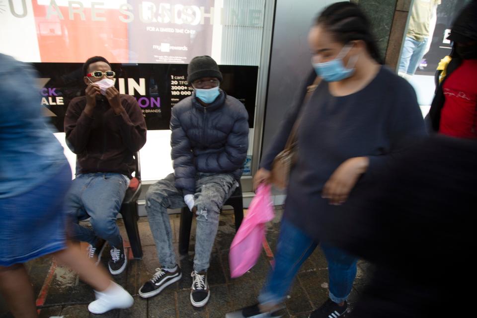 Shoppers wearing face masks on a crowded sidewalk in Pretoria, South Africa, Saturday, Nov. 27, 2021.