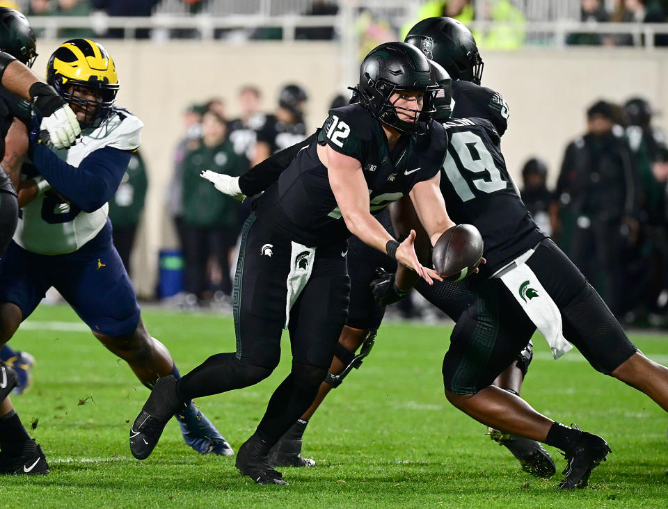 Oct. 21, 2023; East Lansing, Michigan; Michigan State Spartans quarterback Katin Houser (12) pitches the ball to a running back in the first quarter against the Michigan Wolverines at Spartan Stadium. Dale Young-USA TODAY Sports