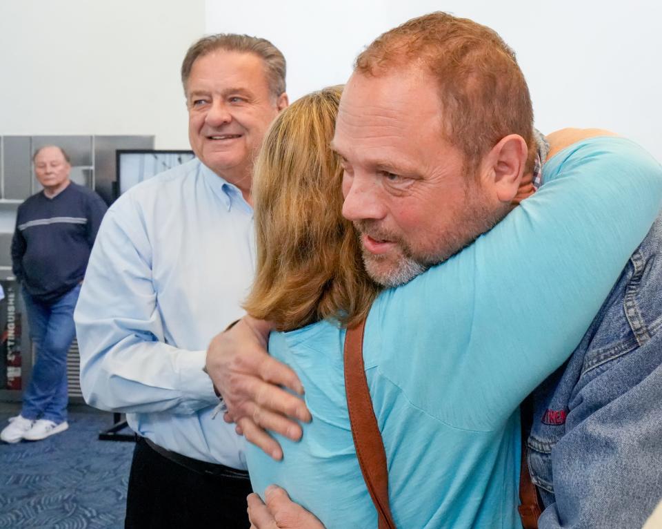 Kevin Heyel hugs Janet Venne, the youngest of the 19 Bultman siblings and the sister who helped Barbara Kreft search for her son over the years. At left is Ralph Bultman, who connected mother and son through DNA testing. The family met for the first time in October at Milwaukee Mitchell Airport.