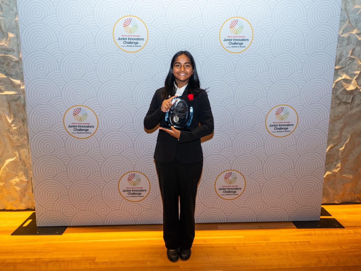 Shanya Gill posing with an award.