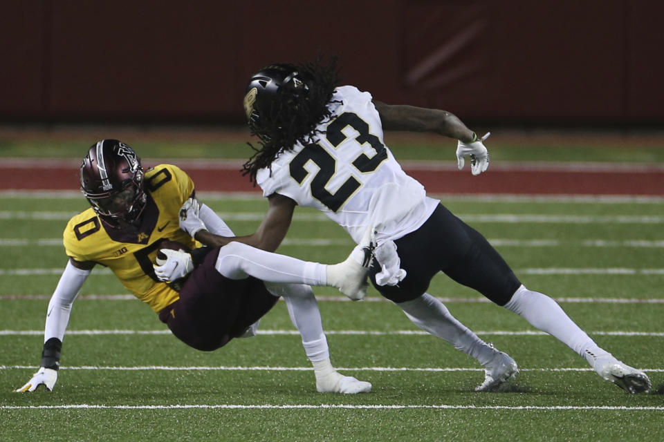 Minnesota wide receiver Rashod Bateman (0) falls after catching a pass, next to Purdue safety Cory Trice (23) during the second half of an NCAA college football game Friday, Nov. 20, 2020, in Minneapolis. Minnesota won 34-31. (AP Photo/Stacy Bengs)