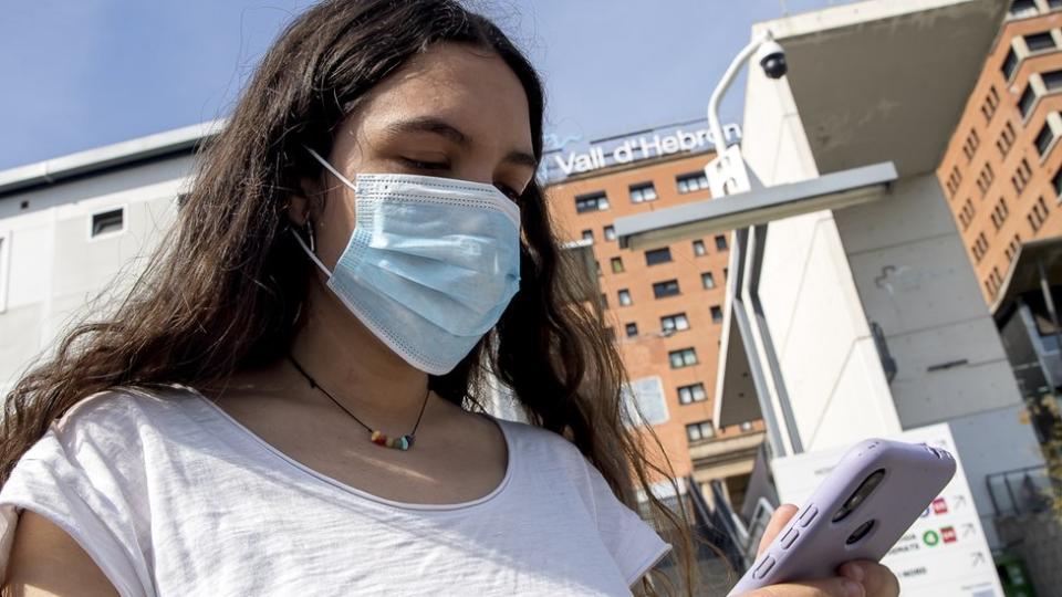 Una mujer con mascarilla frente al hospital Vall d´Hebron