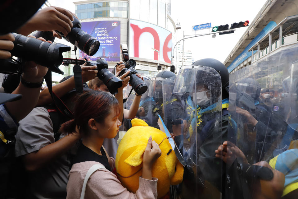 Protesters stand in front of police during a demonstration near the Asia-Pacific Economic Cooperation (APEC) forum venue, Thursday, Nov. 17, 2022, in Bangkok Thailand. A small but noisy group of protesters scuffled briefly with police demanding to deliver a letter to leaders attending the summit demanding various causes including removal of Prime Minister Prayuth Chan-ocha and abolition of Thailand's strict royal defamation laws. (AP Photo/Sarot Meksophawannakul)