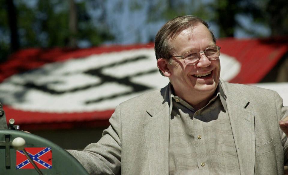 <p> FILE - In this May 22, 2001, file photo, Norm Gissel smiles as he talks about the imminent dismantling of the former headquarters of the Aryan Nations in Hayden Lake, Idaho. Behind Gisel is a Nazi insignia painted atop the roof of the compound's cafeteria. Nearly two decades after the Aryan Nations compound was demolished in Idaho, far-right extremists are maintaining a presence in the Pacific Northwest. (AP Photo/Elaine Thompson, File) </p>