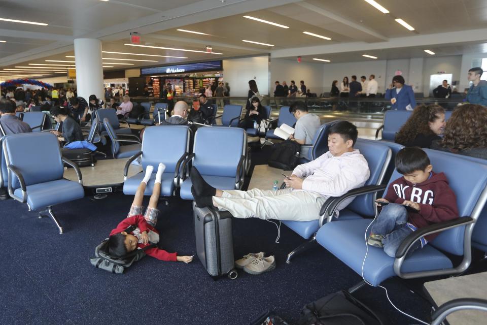 Passengers wait for their flights at the new Delta airlines terminal 4 at JFK airport, Friday, May 24, 2013 in New York. Delta opened its new $1.4 billion terminal, strengthening its hand in the battle for the lucrative New York travel market. The expanded concourse offers sweeping views of the airport, upscale food and shopping options and increased seating. It replaces a decrepit terminal built by Pan Am in 1960 that was an embarrassing way to welcome millions of visitors to the United States. (AP Photo/Mary Altaffer)