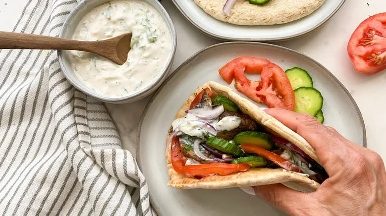 Hand holding mushroom gyro sandwich