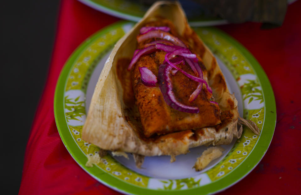 A Cochinita Pibil style tamal is displayed during theTamales fair at the Ixtapalapa neighborhood of Mexico City, Friday, Jan. 27, 2023. Cochinita pibil is a traditional Yucatec Mayan slow-roasted pork dish from the Yucatán Peninsula. (AP Photo/Fernando Llano)