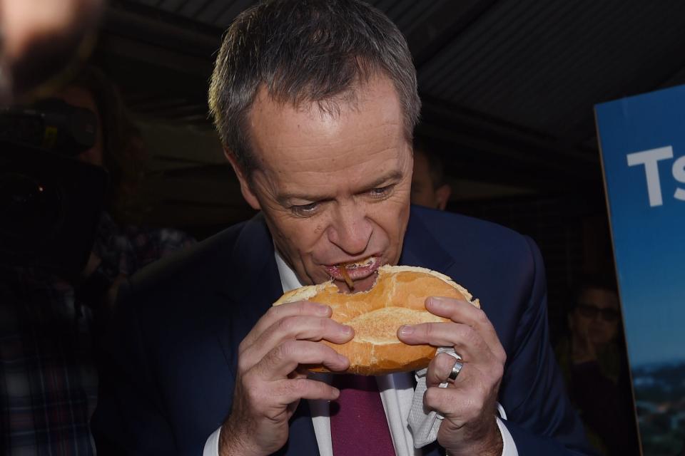 Leader of the Opposition Bill Shorten eats a sausage sandwich at Strathfield North Public School polling booth as part of the 2016 Election Day in Sydney, Saturday, July 2, 2016. (AAP Image/Mick Tsikas) 