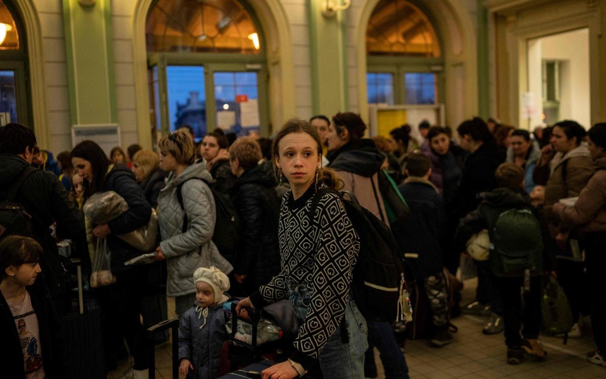 Refugees arrive at a train station in Poland after fleeing their war-torn homeland - ANGELOS TZORTZINIS