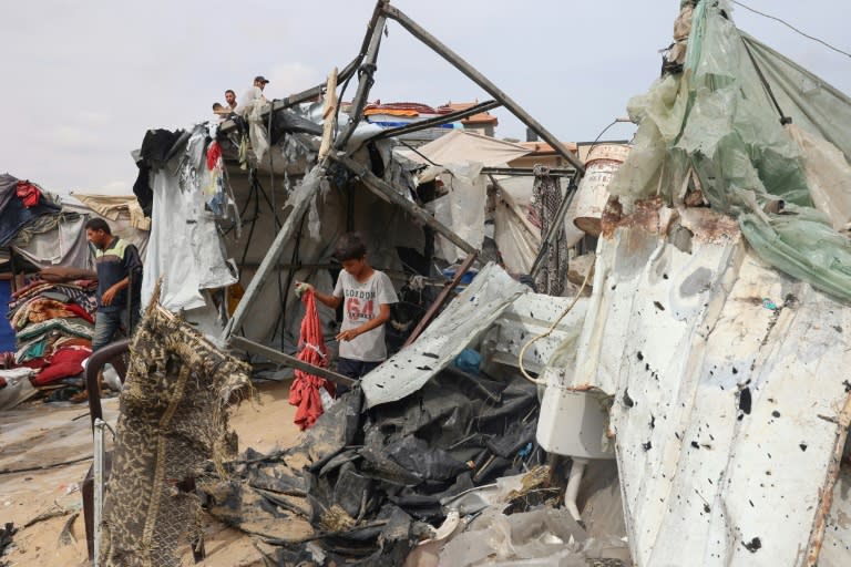 Un niño palestino busca entre los escombros en el campamento de desplazados internos en Rafah, en el sur de la Franja de Gaza, bombardeado por Israel, el 28 de mayo de 2024 (Eyad Baba)