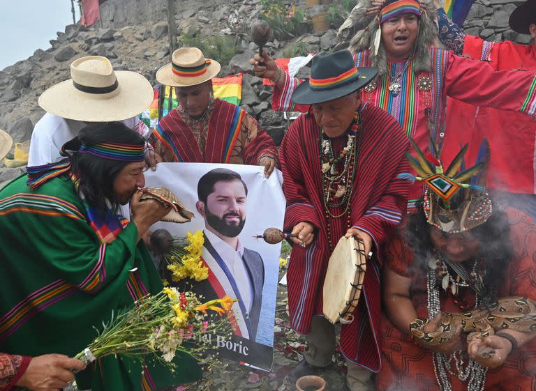 Chamanes peruanos equipados con hojas de coca, espadas, ollas de cerámica humeantes, incienso y una serpiente viva ejecutan un ritual en la cima de una colina sobre Lima para entregar sus predicciones para el el próximo año. Utilizan fotos de varios presidentes durante el encuentro.