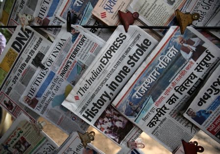 Newspapers, with headlines about PM Modi's decision to revoke special status for the disputed Kashmir region, are displayed for sale at a pavement in Ahmedabad